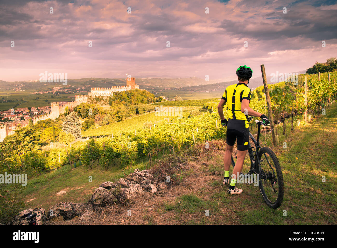 Cyclist admires from the hill the Soave castle views. Stock Photo