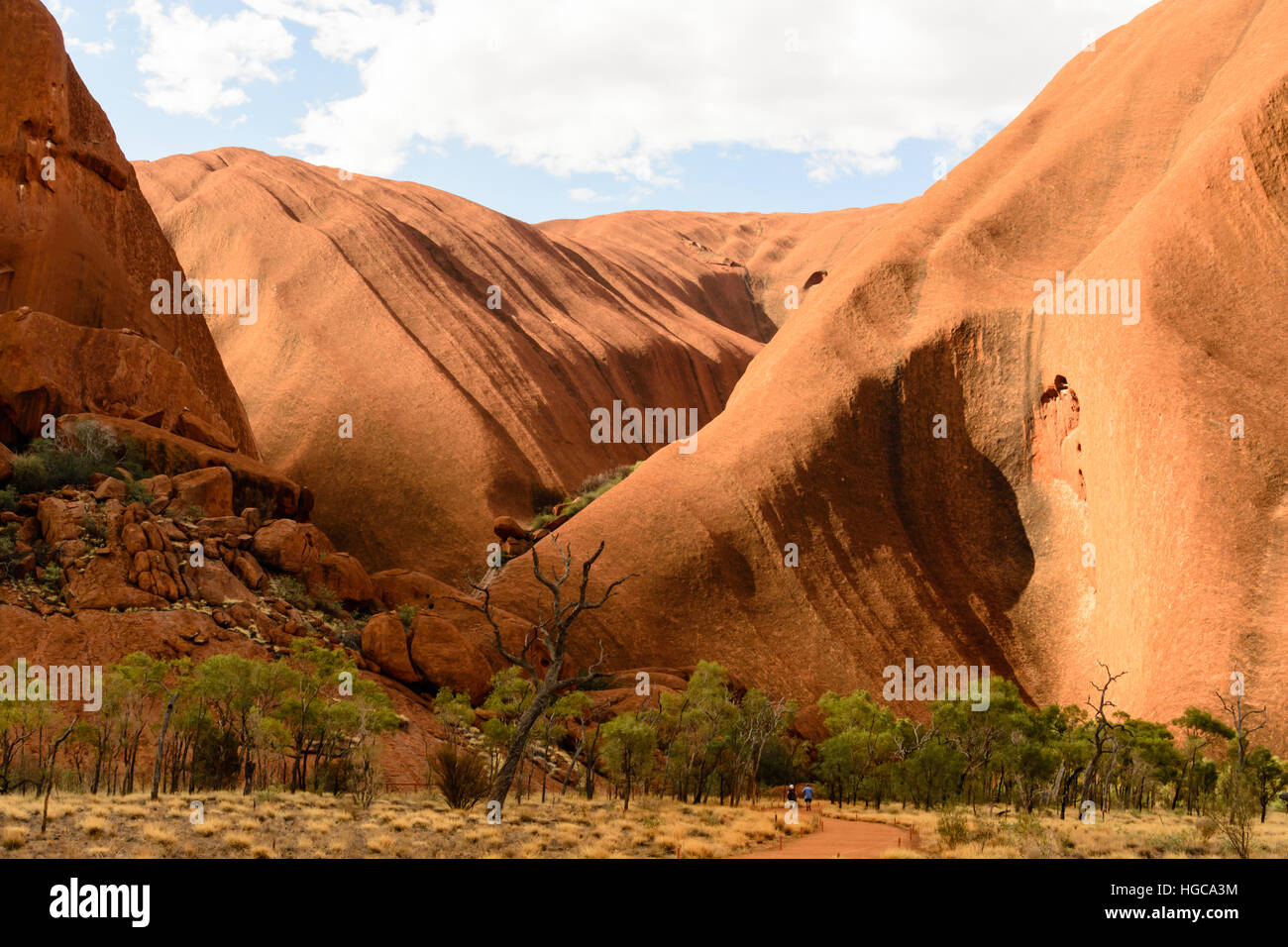 Close-up of Uluru (Ayers Rock) in the Northern Territory, Australia. Two people in front of it show its size. Stock Photo