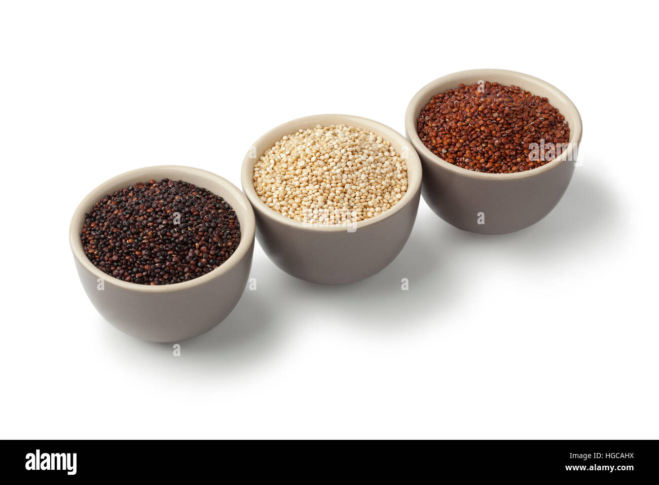 Bowls with raw red, white and black quinoa on white background Stock Photo