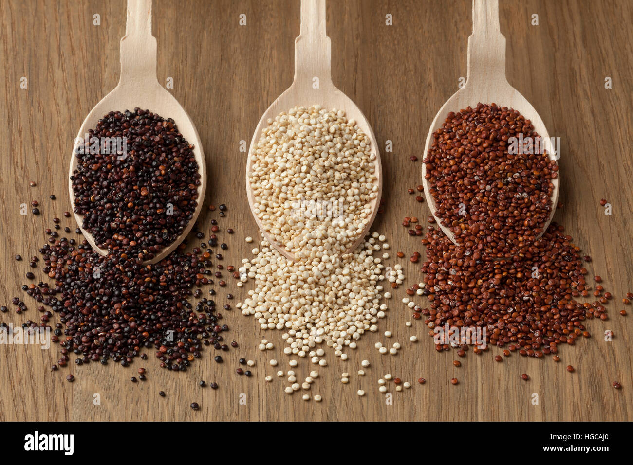 Wooden spoons with raw red, white and black quinoa Stock Photo