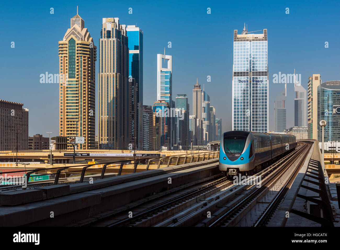 Dubai metro train with city skyline behind, Dubai, United Arab Emirates Stock Photo
