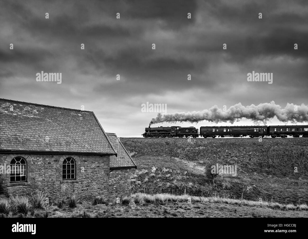 Steam locomotive Galatea on the Settle to Carlisle line passing behind the Mount Zion Chapel having just come off Dandry Mire. Stock Photo