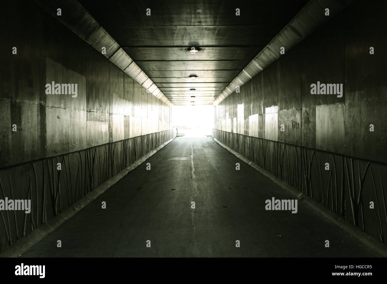 Light At The End Of The Tunnel Pedestrian tunnel illuminated by bright sunlight at the exit Stock Photo