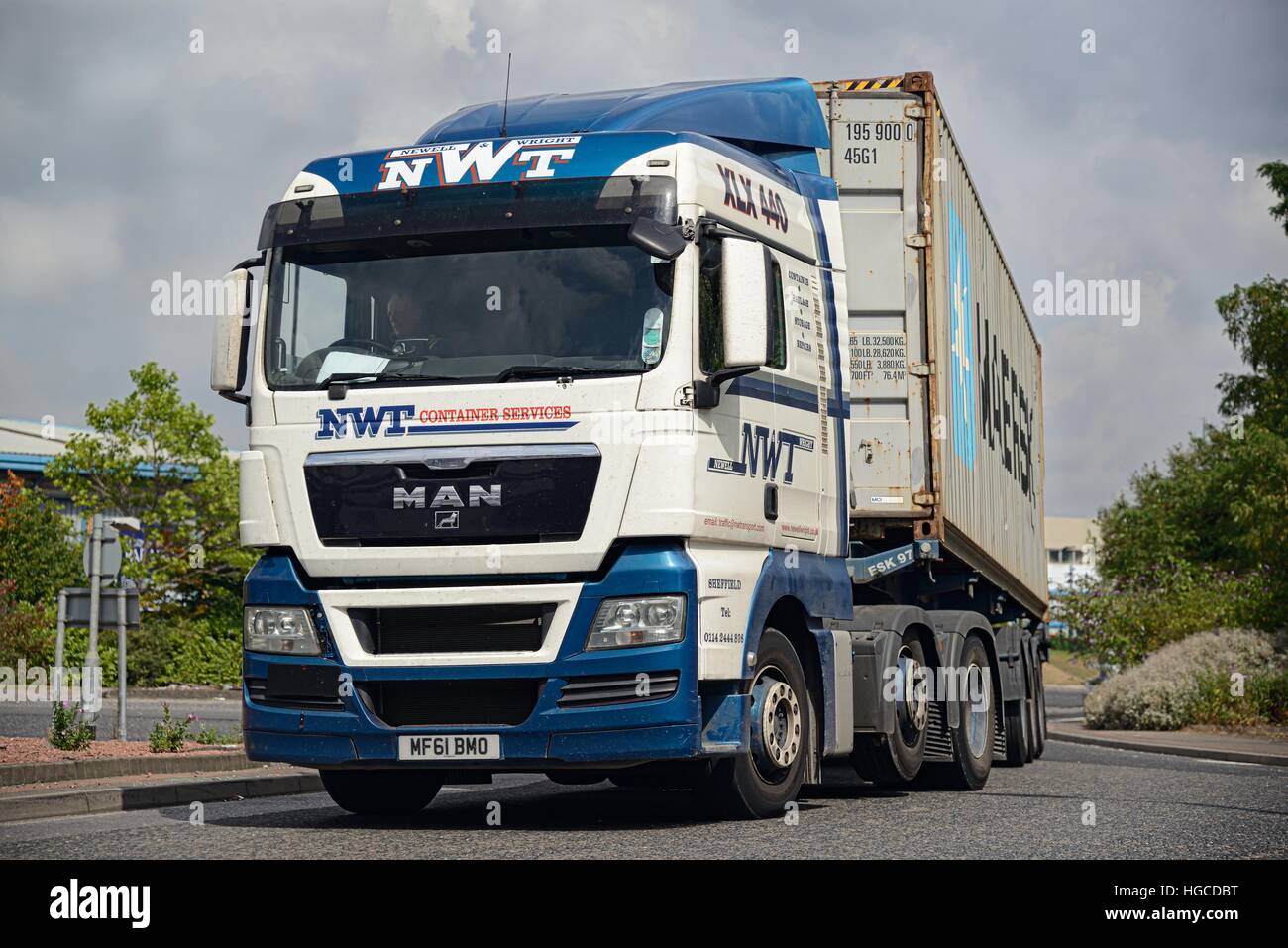 A Newell and Wright MAN container truck rounds a bend near an industrial estate in South Yorkshire Stock Photo
