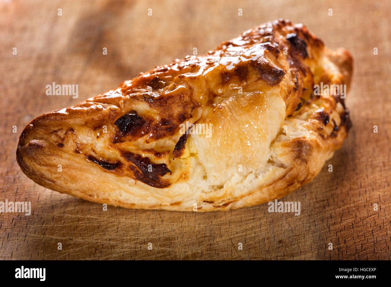 Cheese patty smeared with honey and sesame seeds on wooden background Stock Photo
