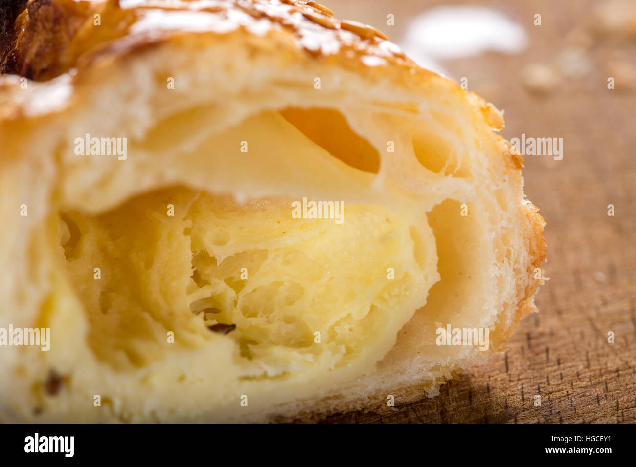 Interior of one cheese patty smeared with honey and sesame seeds on wooden background Stock Photo