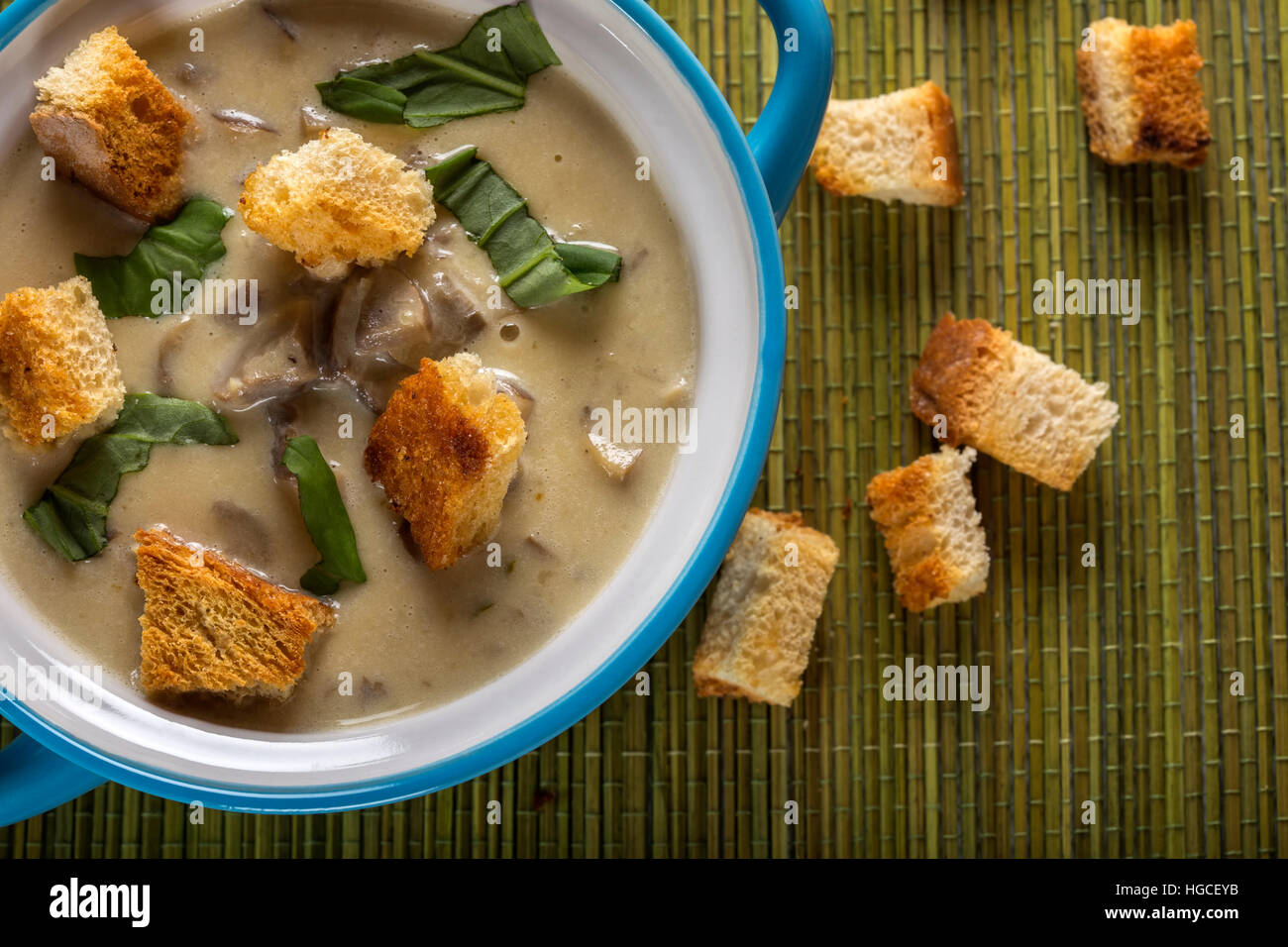 Mushroom cream soup in ceramic bowl and croutons on table Stock Photo