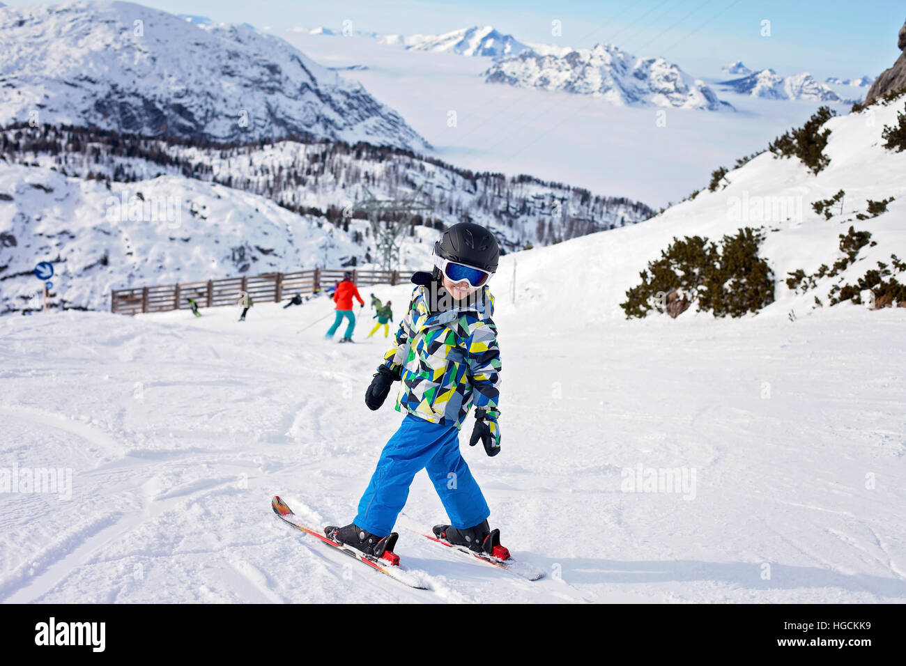 Cute little boy, skiing happily in Austrian ski resort in the mountains ...