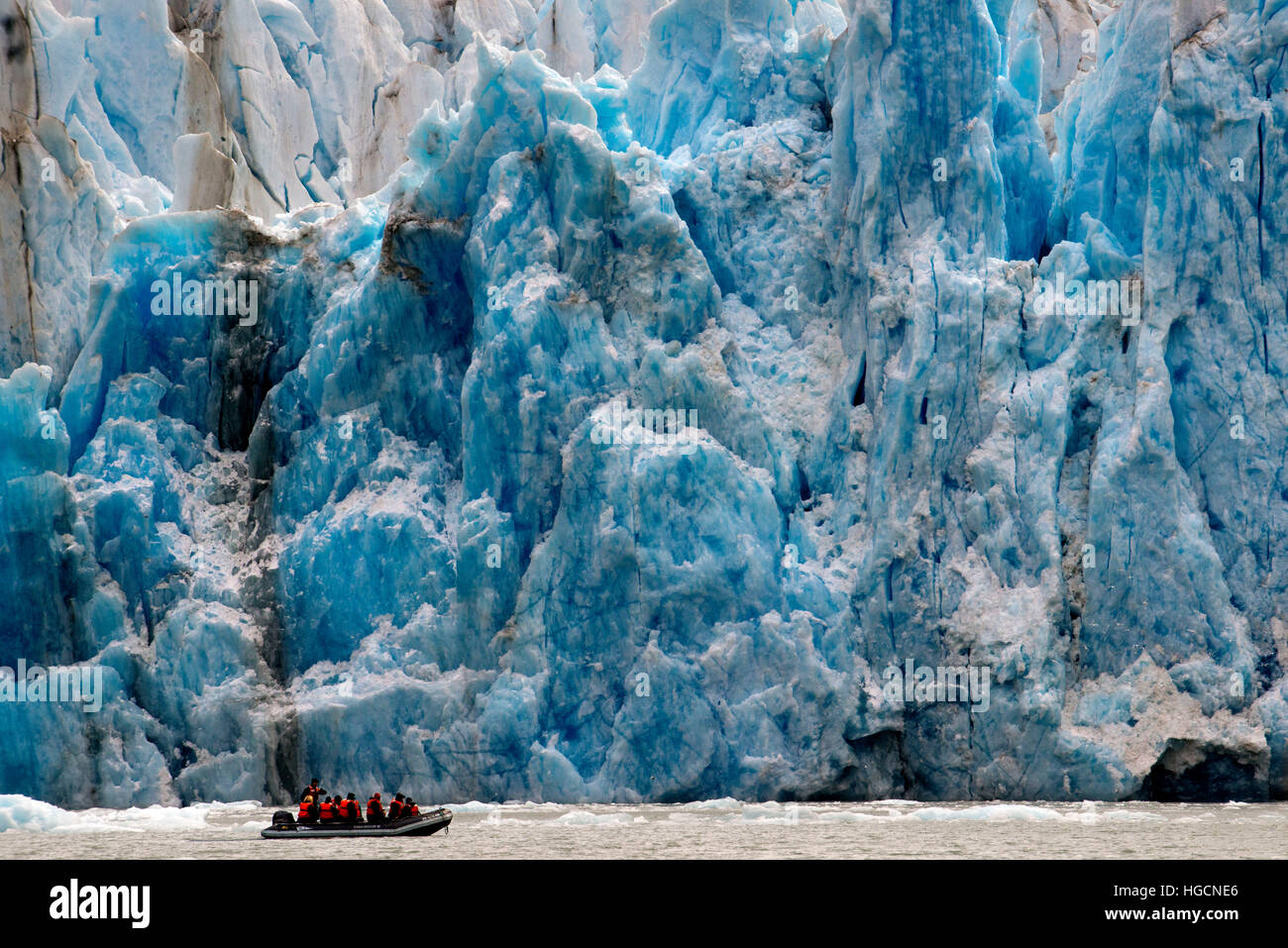 Safari Endeavour cruise passengers in an inflatable boat in front of Dawes Glacier calves into the Endicott Arm fjord of Tracy Arm in Fords Terror Wil Stock Photo