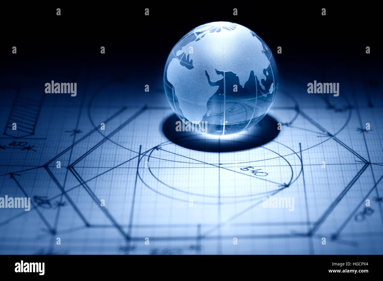 Business concept. Glass globe on graph paper surface with draft Stock Photo