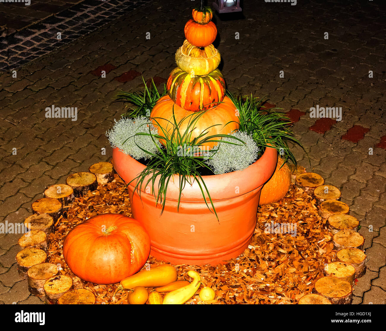 Brightly lit pumpkin pyramid in flowerpot Stock Photo
