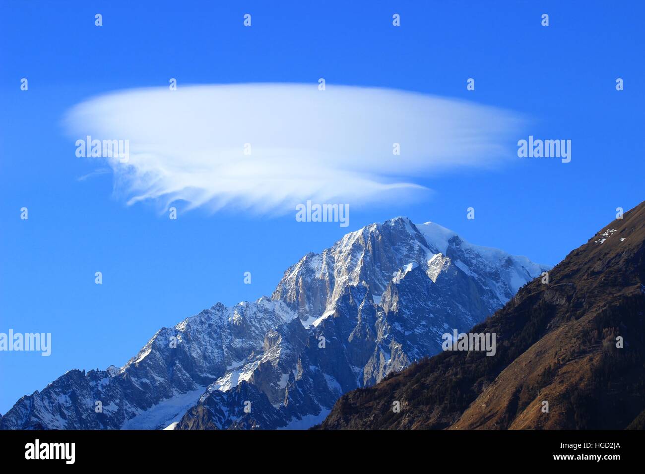 Lenticular clouds (Altocumulus lenticularis) over Mont Blanc peak, blue sky in background Stock Photo