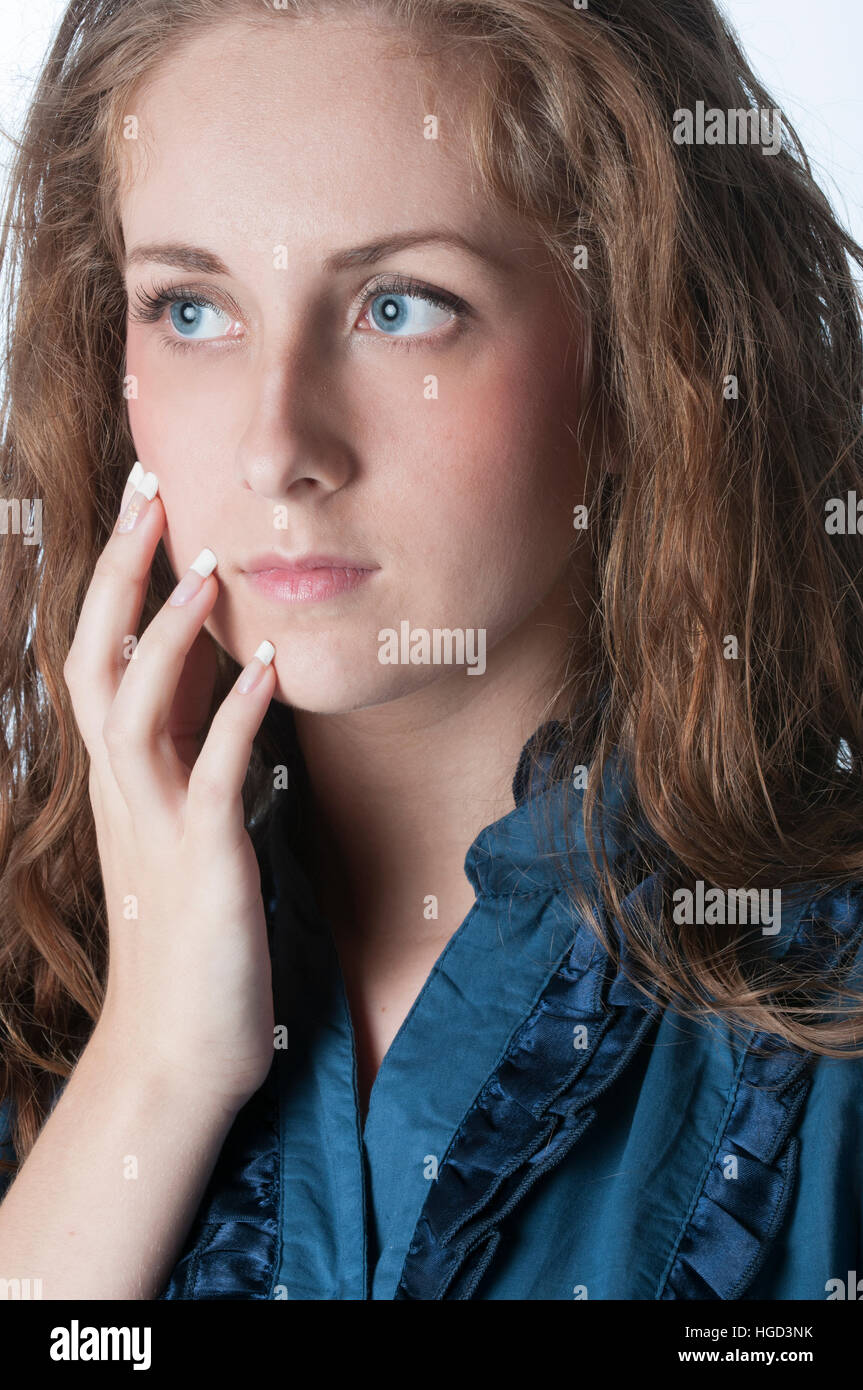 Worried young woman hand touching face looking away Stock Photo - Alamy