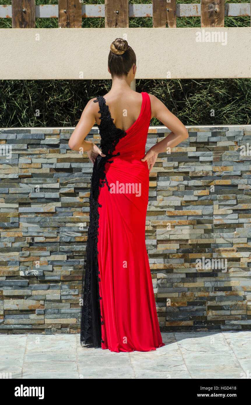 Woman wearing a red dress hands on waist standing outdoors Stock Photo ...