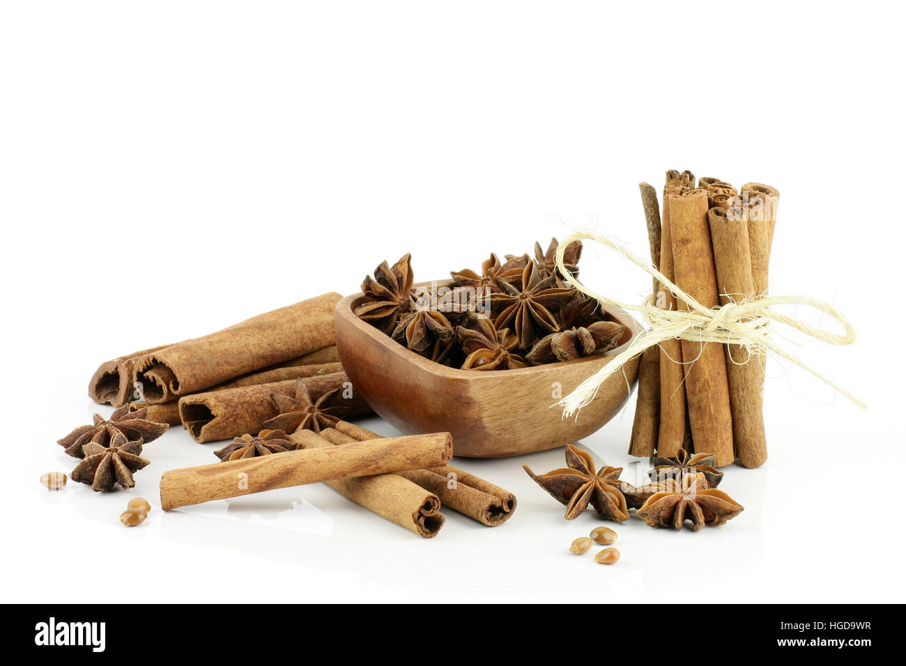 Star anise in a wooden bowl with cinnamon sticks. Stock Photo