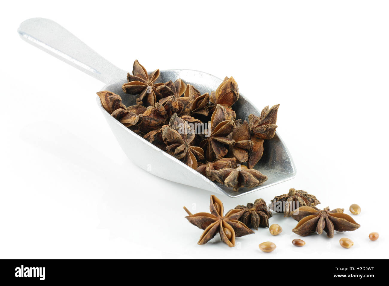Star anise in an aluminium grocery scoop. On a white background. Stock Photo