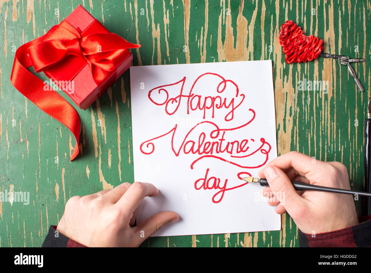 Man writing a Valentines day card and preparing a present Stock Photo