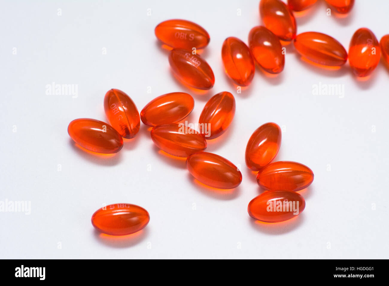 A large group of clear red antigas simethicone pills against a white