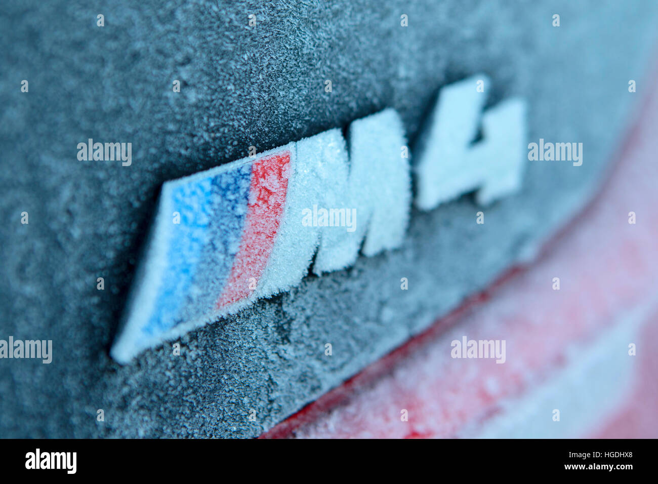 Ice and frost close up detail of a Black F83 2016 BMW M4 Convertible badge Stock Photo