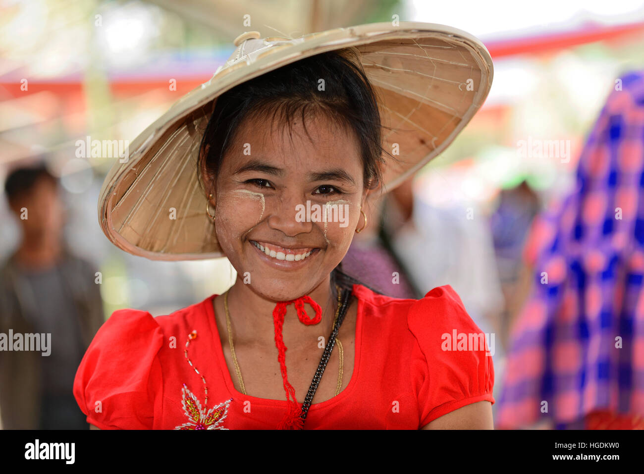 Local woman with straw hat and Thanaka paste on her face, smiling, Mandalay, Myanmar Stock Photo