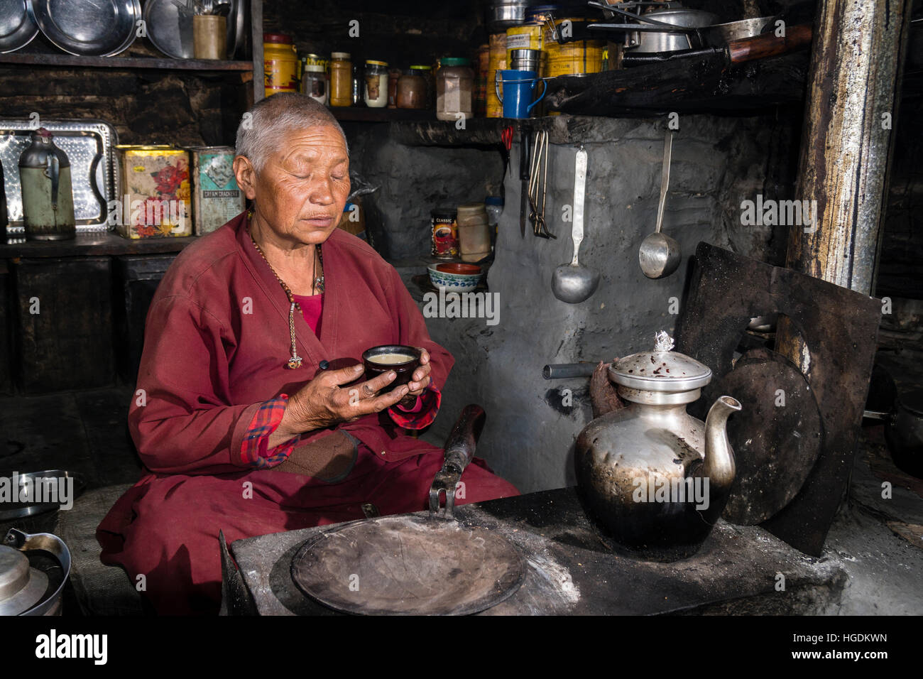 Ani Chorten, daughter of Tashi Lama, is praying before drinking tibetan butter tea, Praken Gompa, Manang, Manang District, Nepal Stock Photo