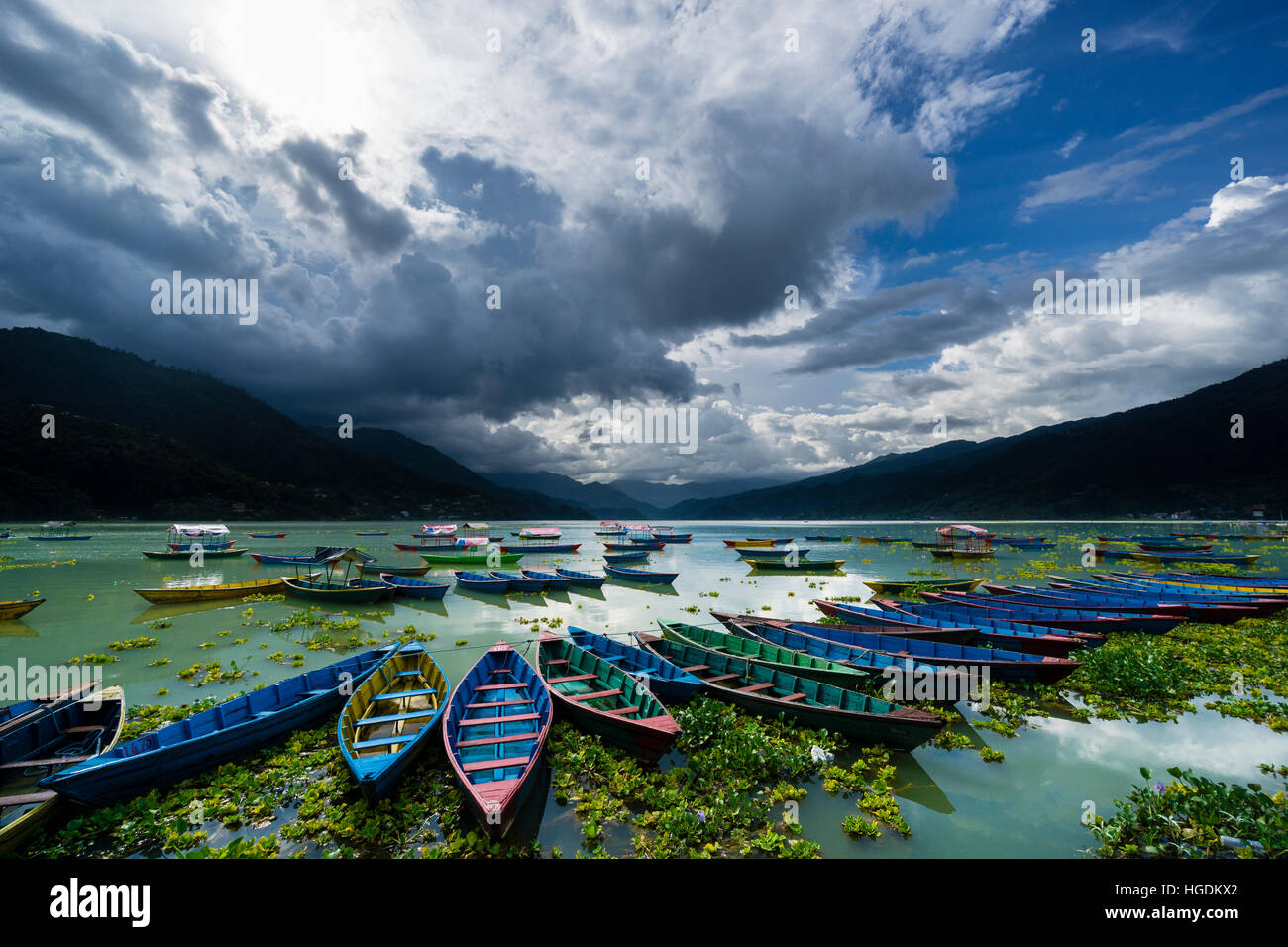 Rowing boats are tight together at Phewa Lake, dark thunderstorm clouds are rising at the sky, Pokhara, Kaski District, Nepal Stock Photo