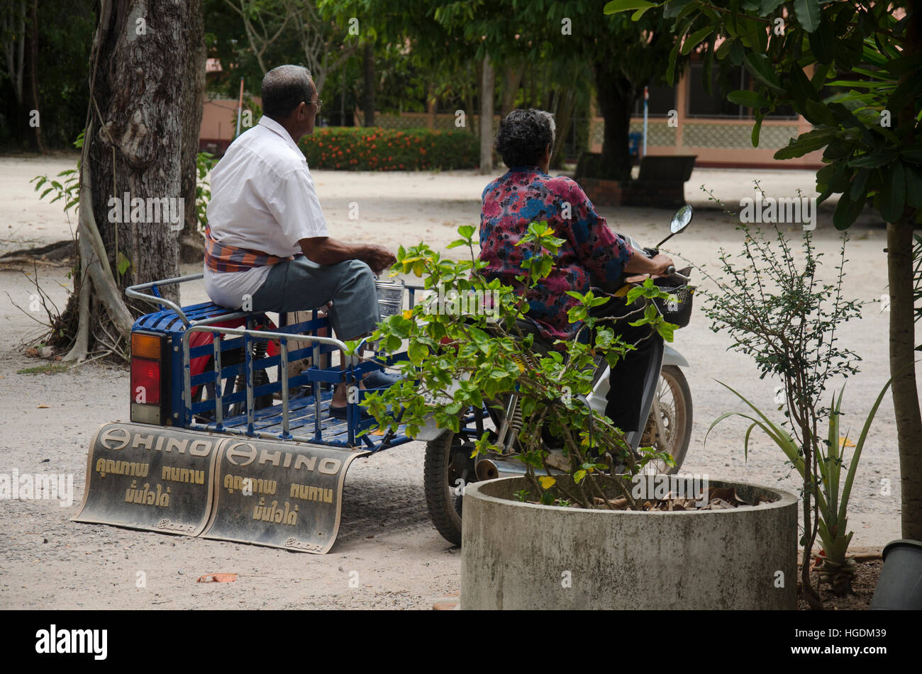 Old woman riding motorcycle and old man sit at cart go back home after join merit at Wat Khuan Maprao temple on September 27, 2016 in Phatthalung, Tha Stock Photo