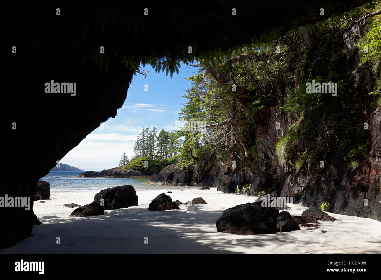 White sandy beach and rocky sea stacks framed by sea cave, San Josef Bay, Cape Scott Provincial Park, Vancouver Island, Canada Stock Photo