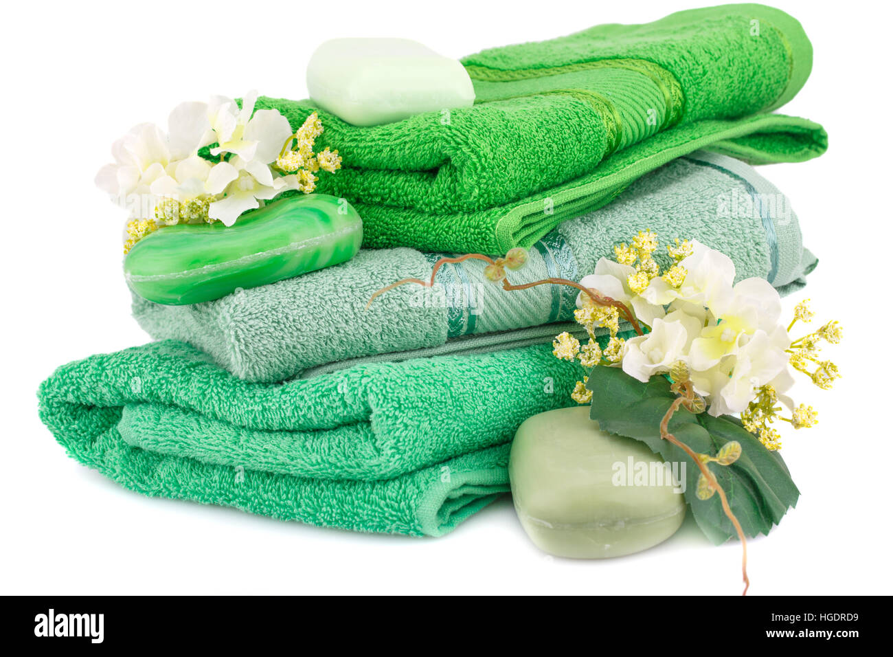 Folded towels, soaps and flowers isolated on white background. Stock Photo