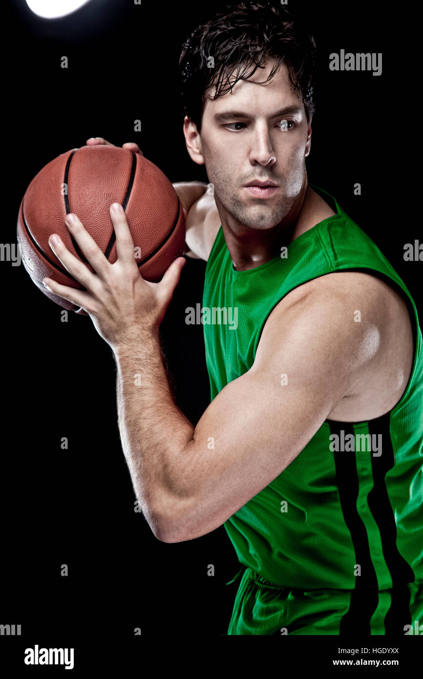 Basketball player with a ball in his hands and a green uniform