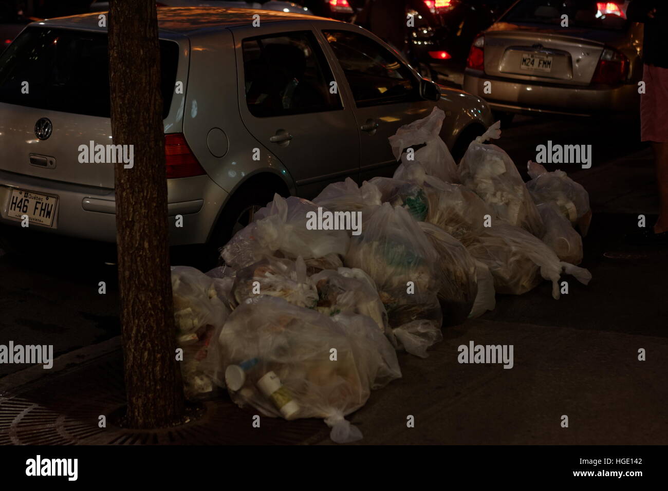 Garbage bags place on the edge of a city sidewalk. Stock Photo