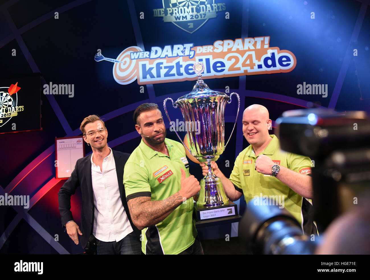 Star Time Wiese (M) and Dutch Darts world champion Michael van Gerwen (m-R) celebrate their win with a trophy during the 'Promi-Darts-WM' event Duesseldorf, Germany, 07 January 2017. To the