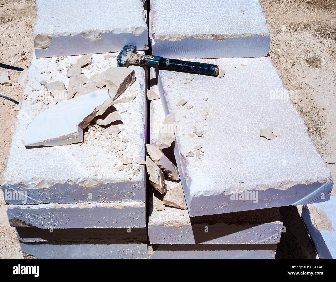 Building hammer, pile of limestone slabs carved road pavement. Featured