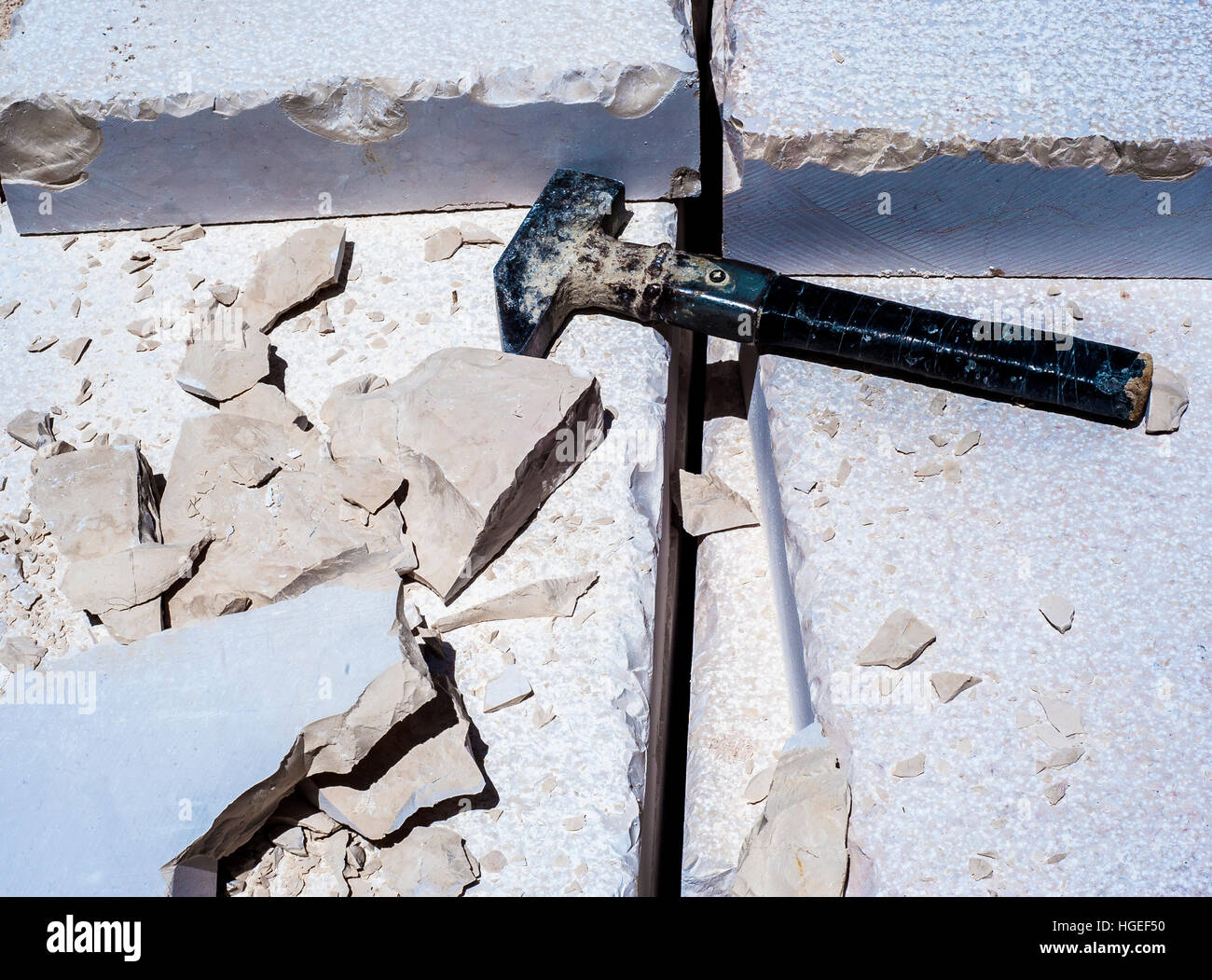 Building hammer, pile of limestone slabs carved road pavement. Featured
