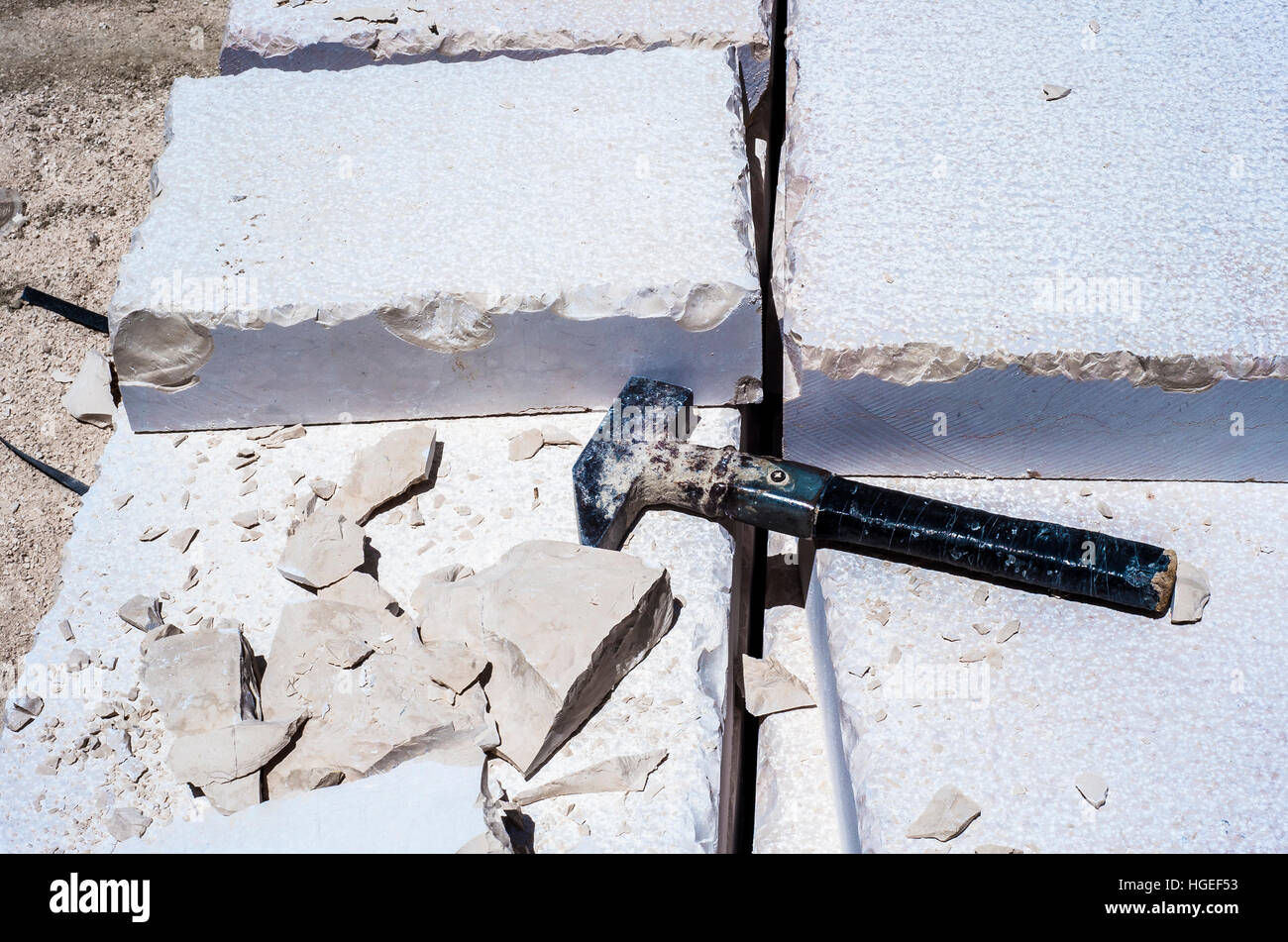 Building hammer, pile of limestone slabs carved road pavement. Featured