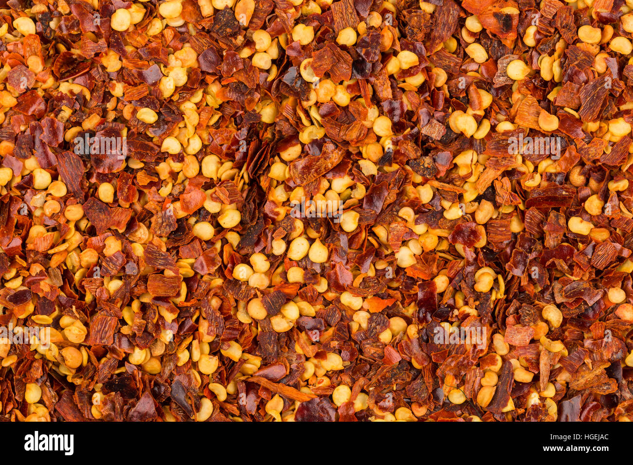 The pile of a crushed red pepper, dried chili flakes and seeds as a