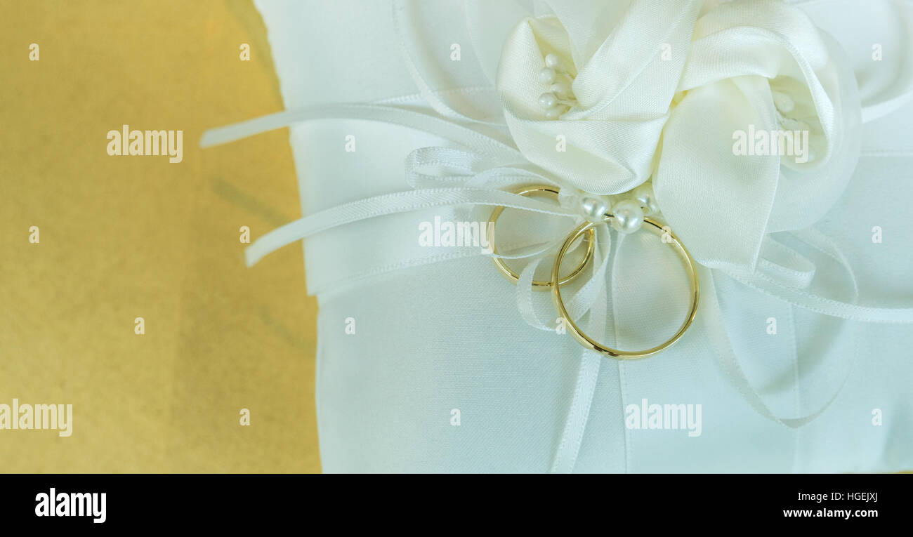 White pillow with two golden wedding rings Stock Photo Alamy