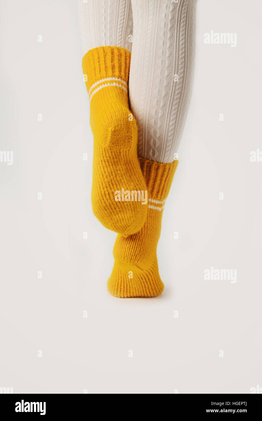 Female legs in white stockings and yellow knitted socks Stock Photo Alamy