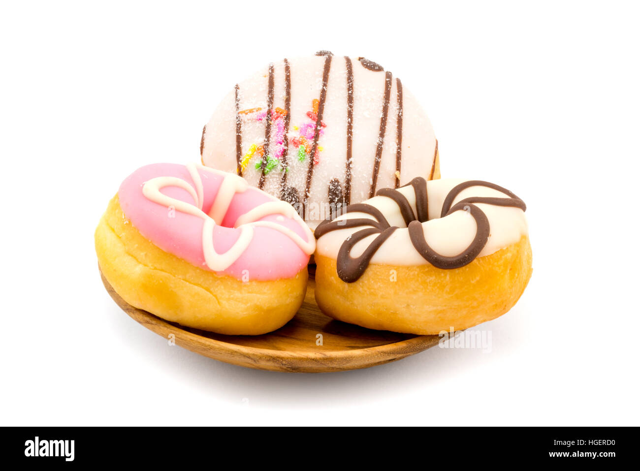 Colorful tasty doughnuts in wooden plate on white background Stock Photo