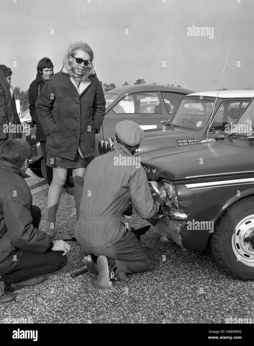 Miss Bronwyn Burrell, of Sutton and Cheam Motor Club, watches as officials and fitters examine her Sunbeam Imp, which was damaged when a car reversed into her whilst driving to the Royal Automobile Club Rally scrutineering point at the Centre Airport Hotel, Heathrow, London. Stock Photo