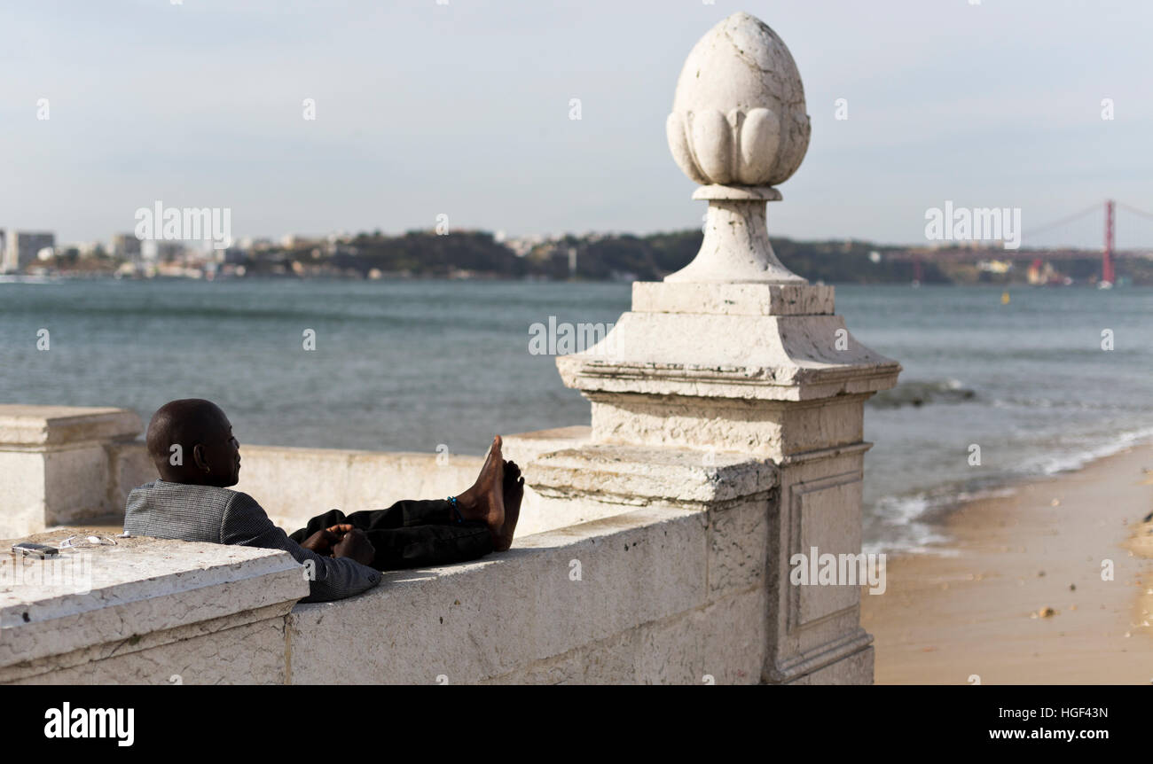 Person enjoying the good weather by the Tagus River in downtown Lisbon, Portugal Stock Photo