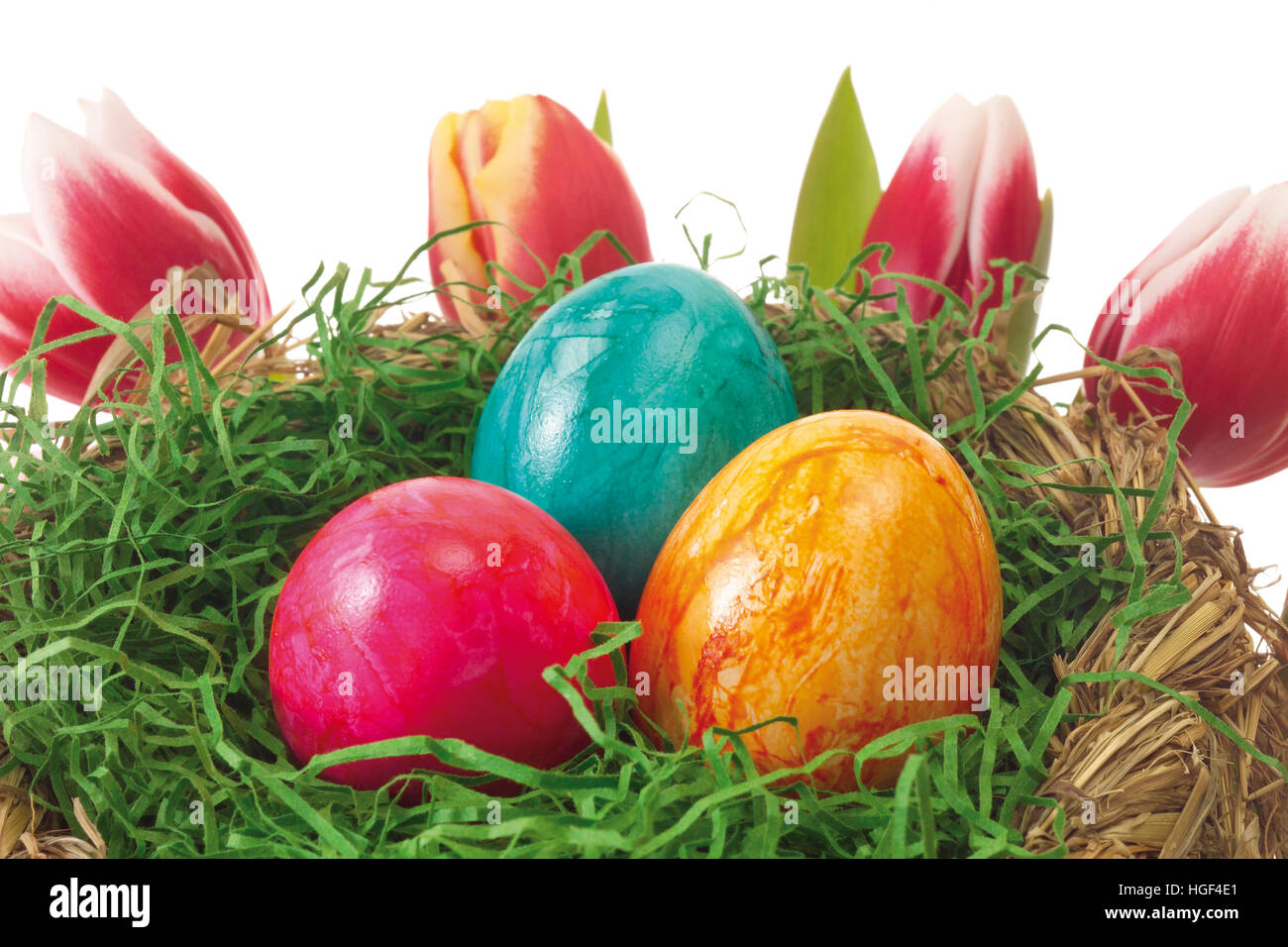 Easter nest with colourful eggs and tulips in the background Stock ...