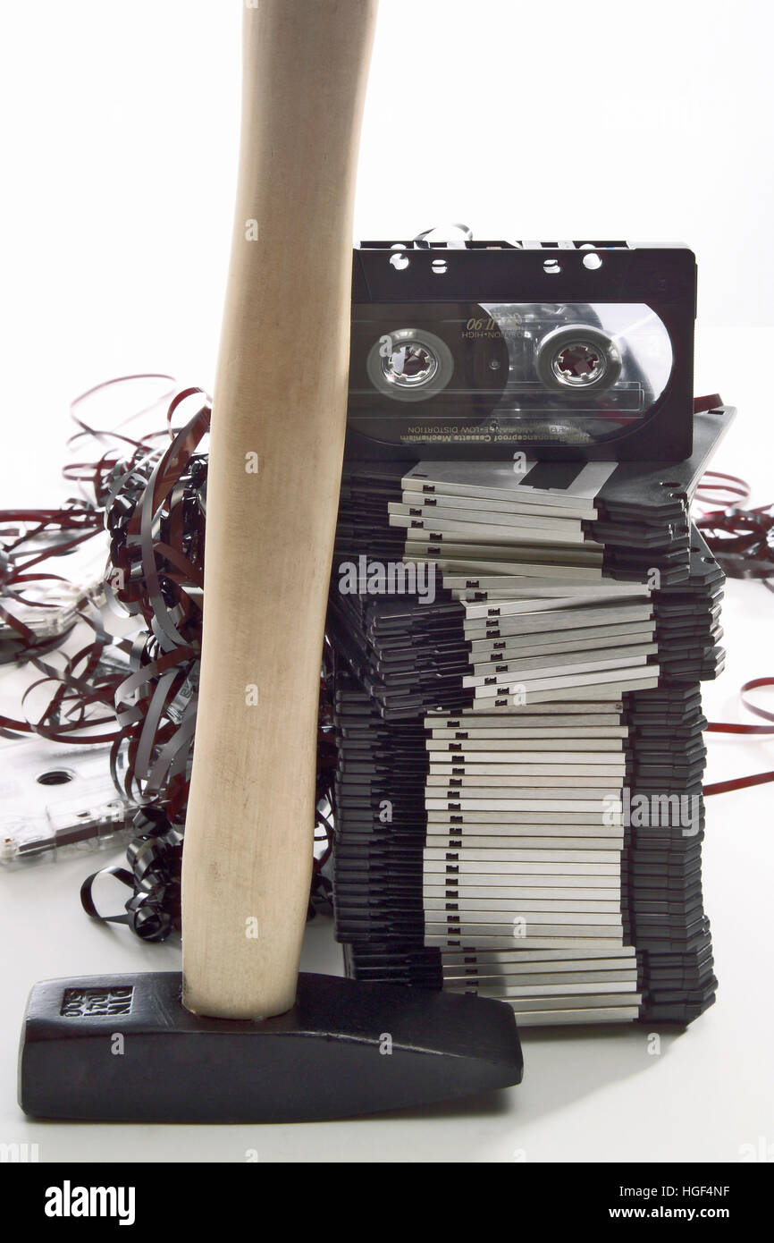 Hammer in front of a stack of floppy disks and an audio tape, jammed