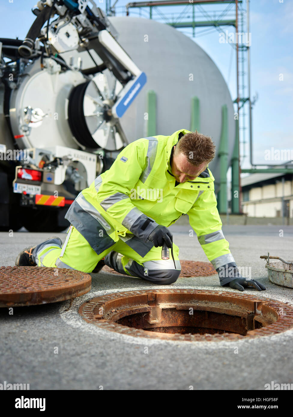 Sewer cleaning, gas storage facility, worker inspecting channel with flashlight, Innsbruck, Tyrol, Austria Stock Photo