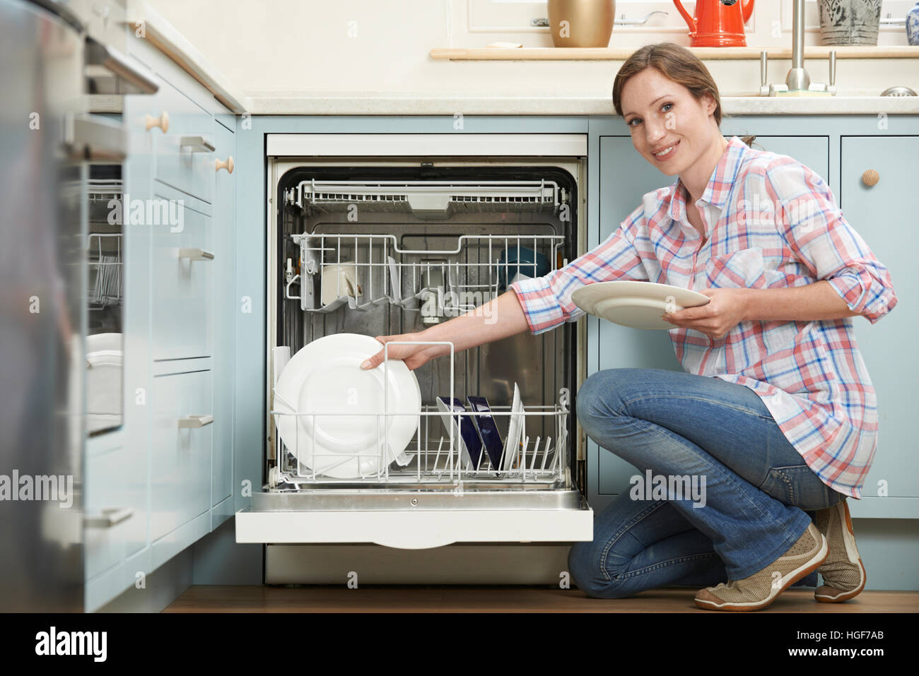 https://c8.alamy.com/comp/HGF7AB/woman-loading-dishwasher-in-kitchen-HGF7AB.jpg