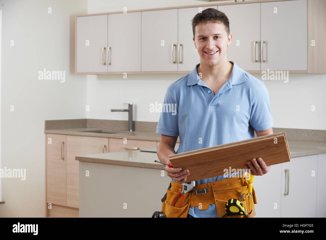 Portrait Of Carpenter Installing Fitted Kitchen Stock Photo