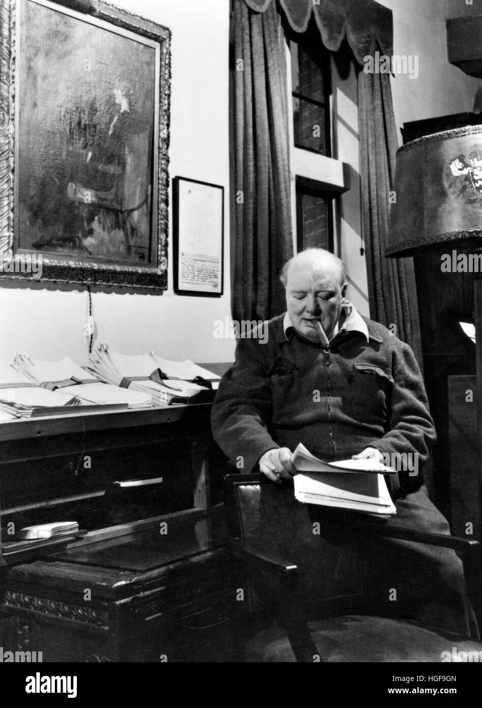 Winston Churchill reading in his study underneath a portrait of his wife Clementine .Chartwell. 1947 Stock Photo