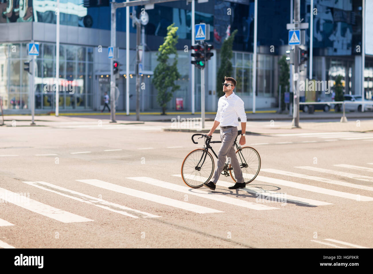 young man with bicycle on crosswalk in city Stock Photo