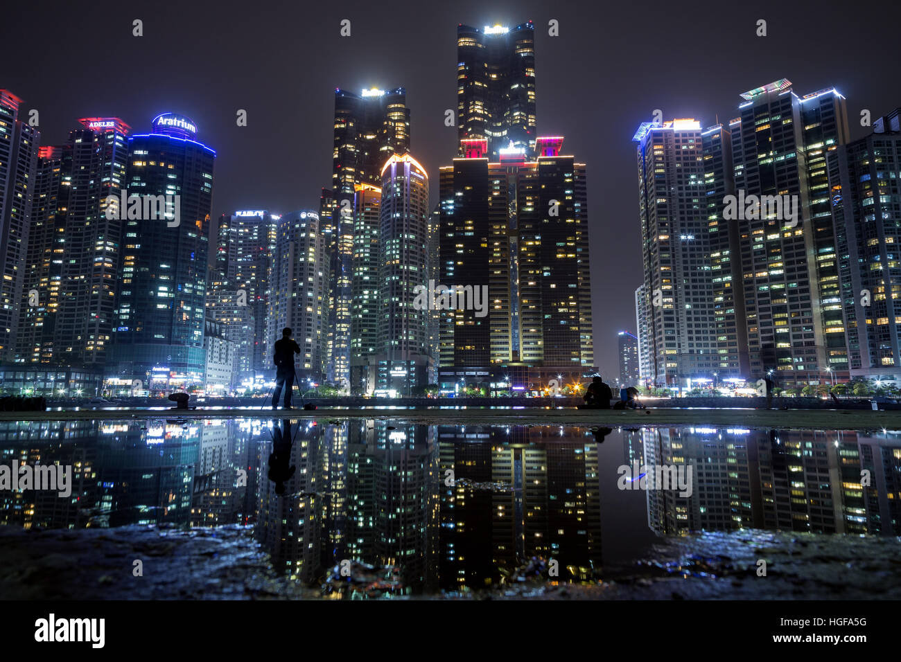 Skyscrapers at Marine City residential area in Haeundae District and their reflection in a puddle in Busan, South Korea at night Stock Photo
