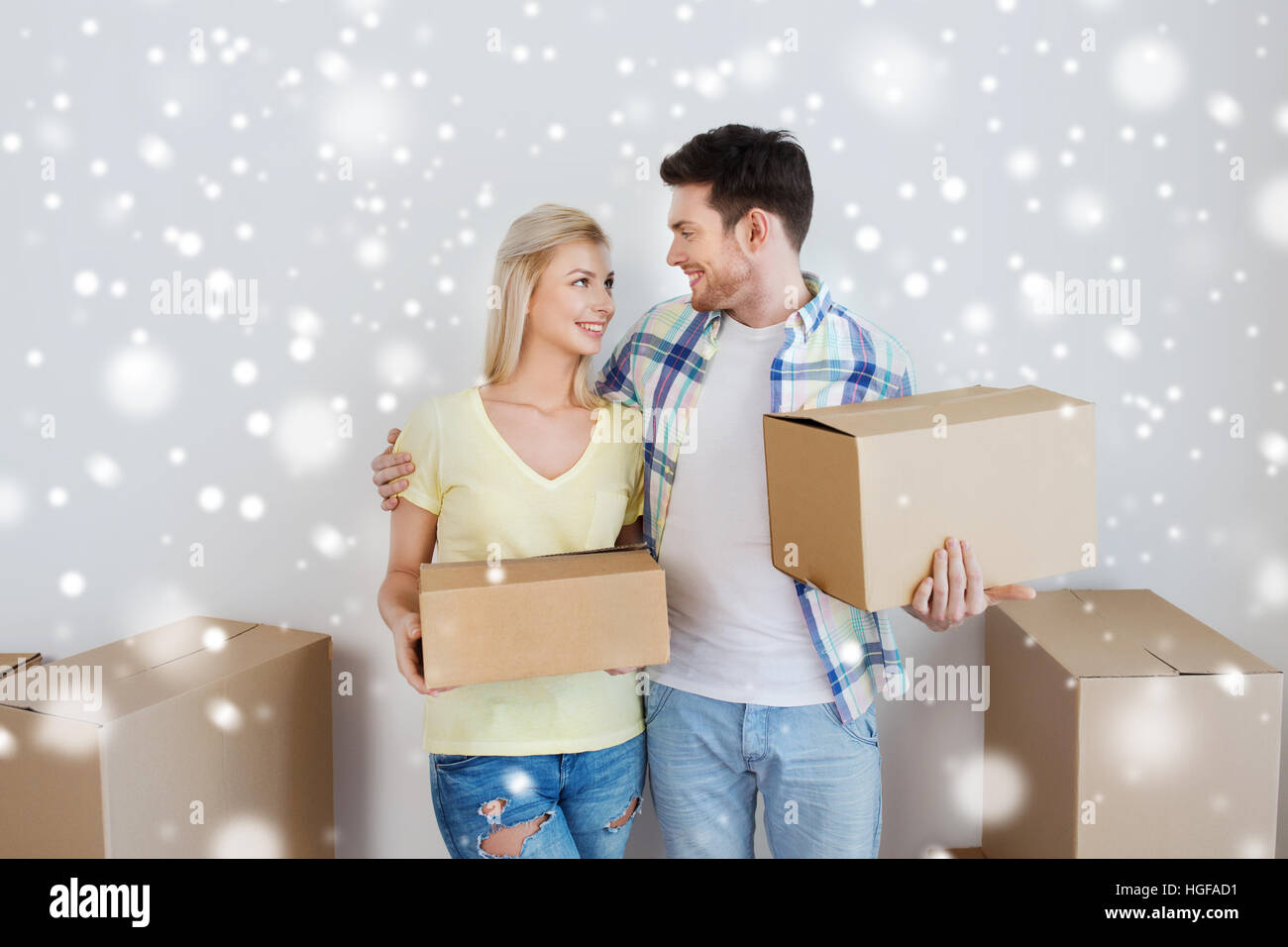 smiling couple with boxes moving to new home Stock Photo - Alamy